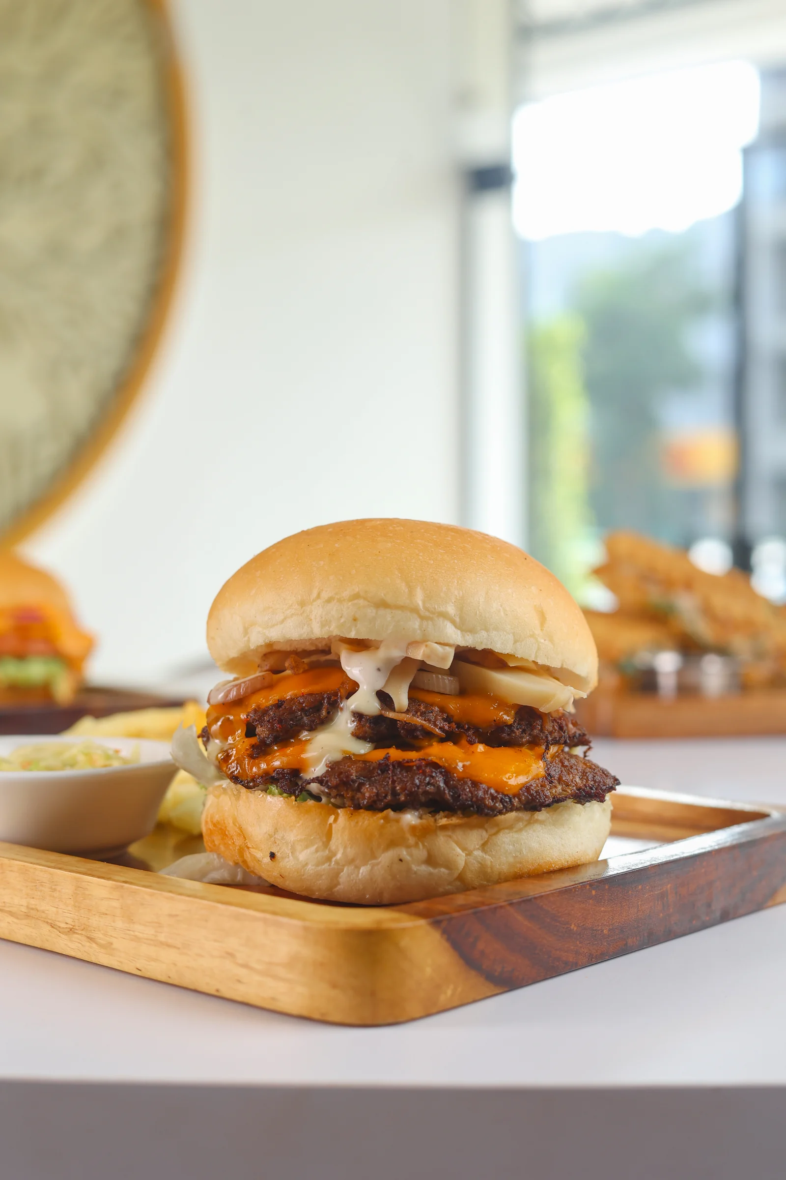 MACKN burger with sauce and caramelised onions, served on a wooden board