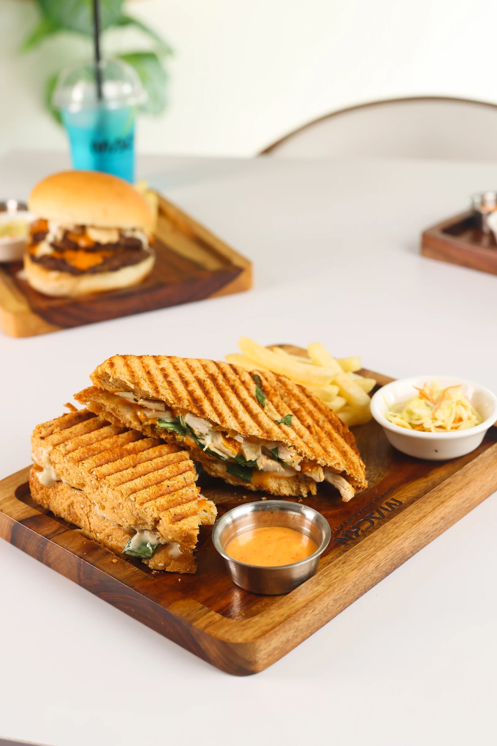 Toasted MACKN sandwiches, fries and coleslaw served on a wooden board